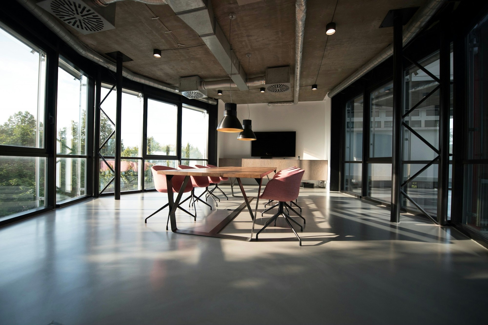 Daylit conference room with a long table and floor-to-ceiling windows